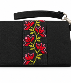 Black handmade Palestinian embroidered clutch with red and pink floral cross-stitch, yellow-green details and a detachable wrist strap.