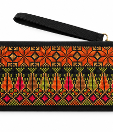 : Hand-embroidered clutch with orange and gold star-like geometric bands, multicoloured vertical motifs in olive, coral, pink and ochre, shown on a white background with a wrist strap.